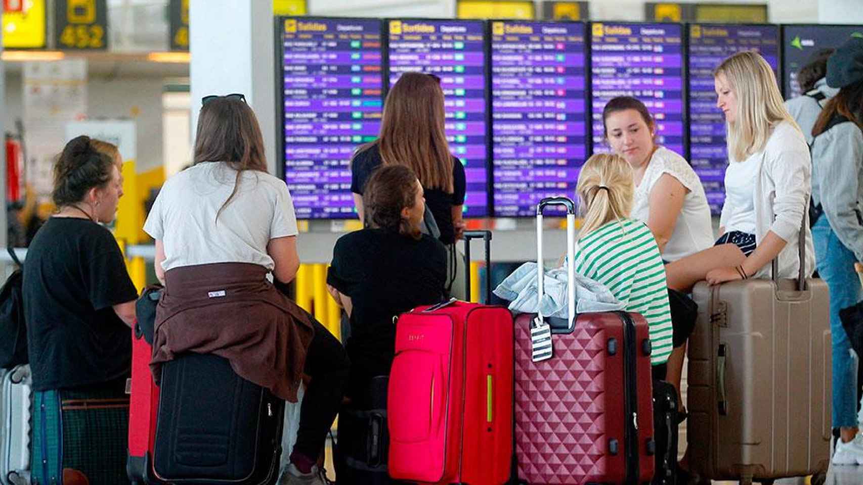 Varias jóvenes afectadas por la huelga de los trabajadores de Iberia en El Prat / EFE