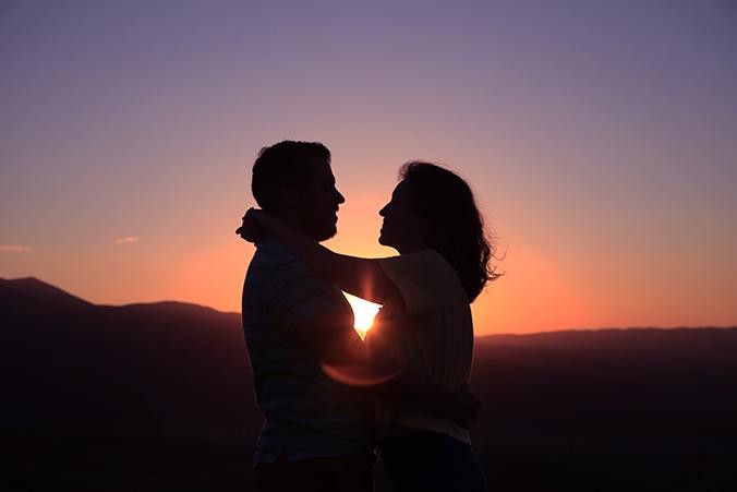 Pareja disfrutando del atardecer en sus vacaciones / VIAJEROSPIRATAS