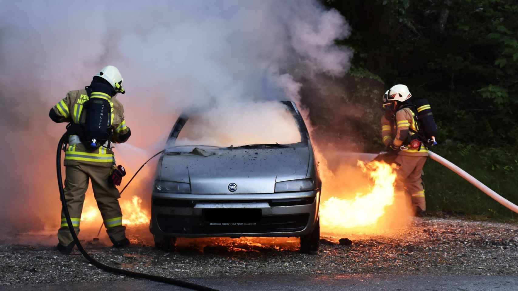 Foto de un coche incendiado, con los bomberos aplicando las labores de extinción / PIXABAY