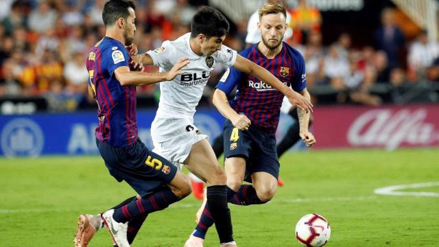 Rakitic y Busquets pelean por un balón con Carlos Soler / EFE