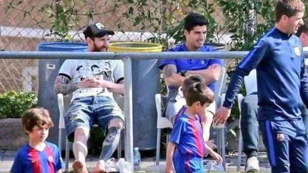 Una foto de Leo Messi y Luis Suárez viendo un partido de sus hijos en la escuela del Barça / Twitter