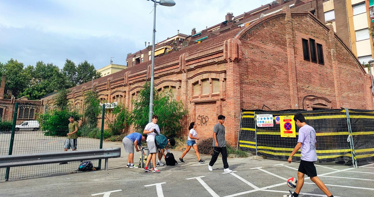 Un grupo de niños jugando ante la antigua fábrica que acogerá el polémico Tanatorio de Sants / CG