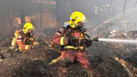 Dos agentes de los Bomberos de la Generalitat apagan un incendio / GENCAT