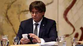 El presidente de la Generalitat, Carles Puigdemont, consulta su teléfono móvil / EFE