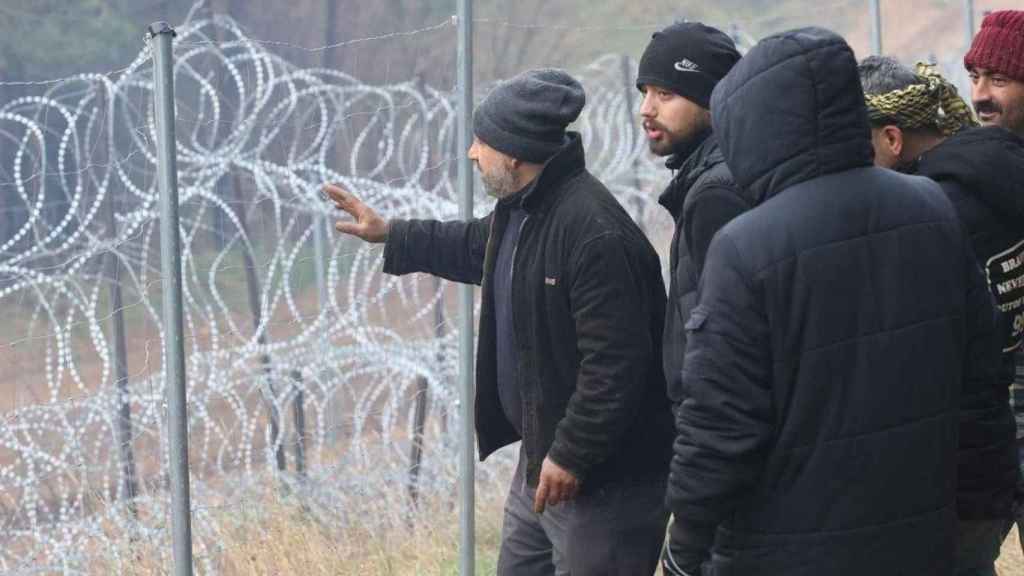 Varias personas reunidas en la frontera polaco-bielorrusa en plena crisis migratoria durante una ola de frío / Leonid Scheglov (EFE)