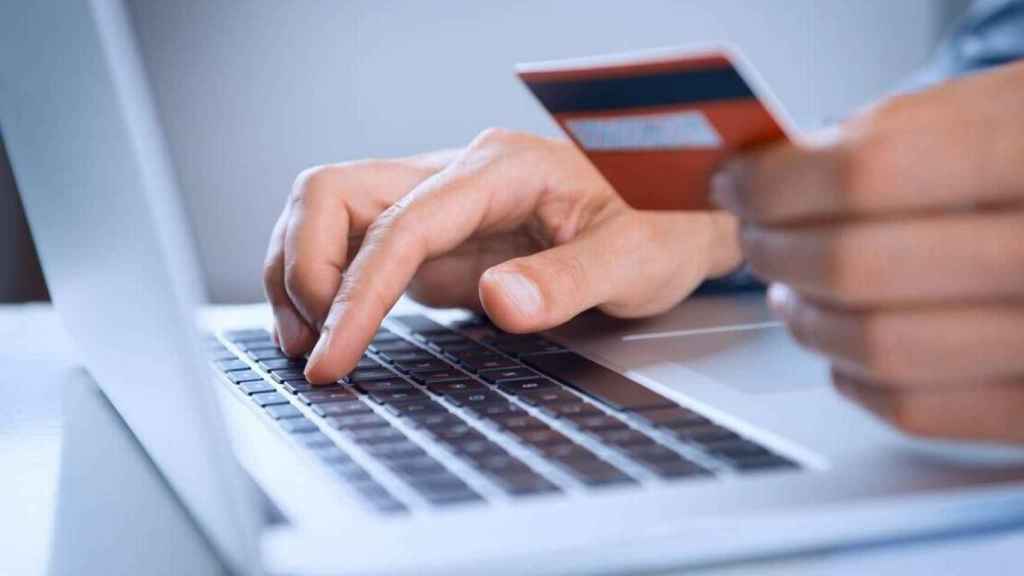 Un consumidor realiza una compra 'online', donde se trasladan las colas de las rebajas