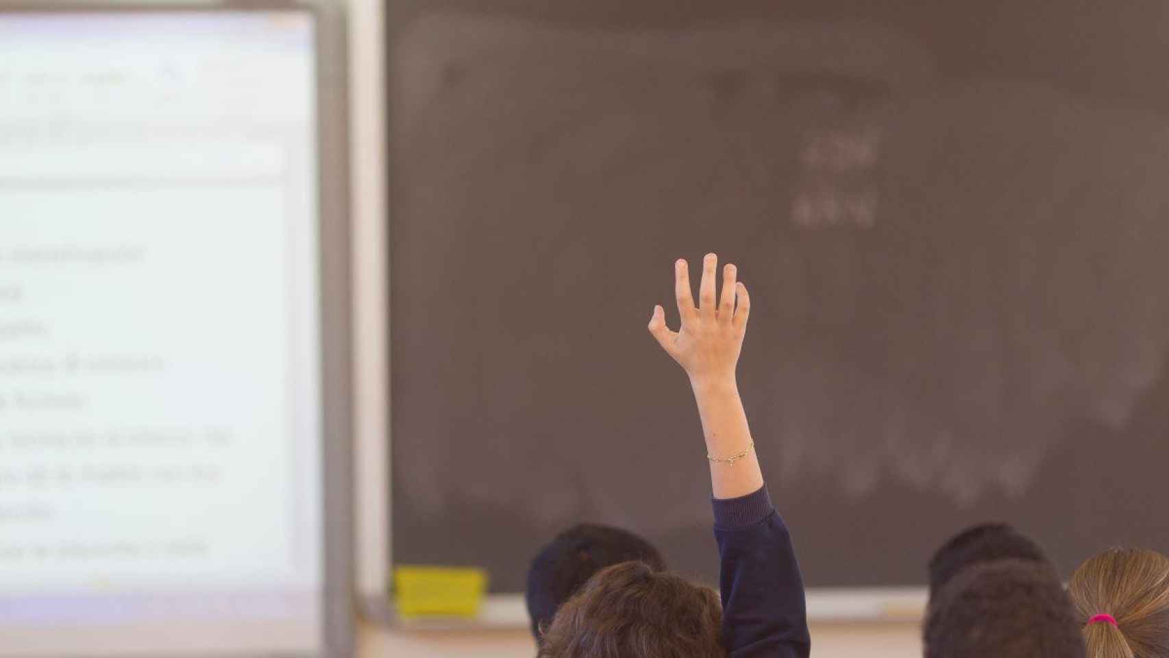 Un alumno levanta la mano durante una clase: el Covid se ralentiza en Cataluña / EP