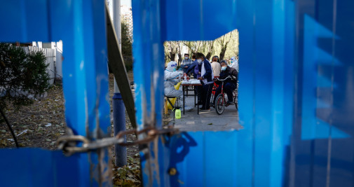 Sanitarios realizando pruebas de Covid-19 en un recinto vallado en Pekín / EFE - Mark R. Cristino