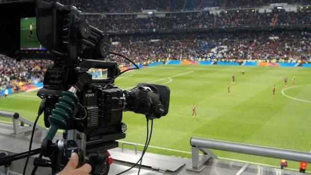 Cámara de televisión graba un partido de fútbol profesional