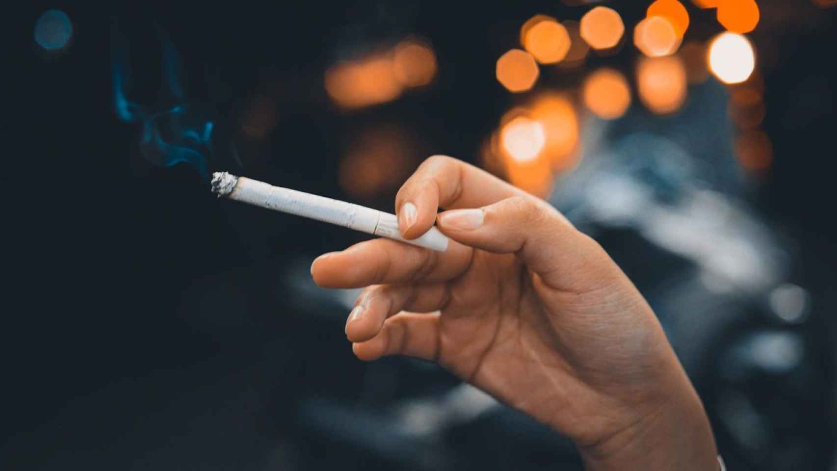 Una persona con un cigarro en su mano