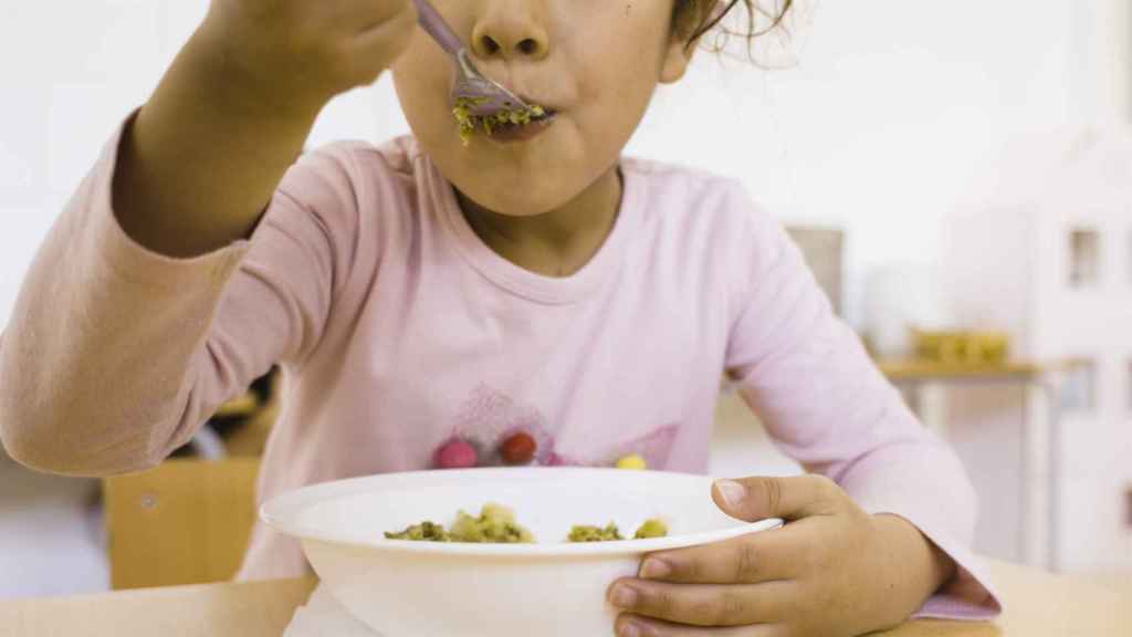 Niña comiendo en el comedor escolar