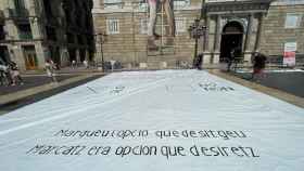 Pancarta reproduciendo una papeleta del  referéndum ilegal del 1-O desplegada por en la plaza Sant Jaume de Barcelona