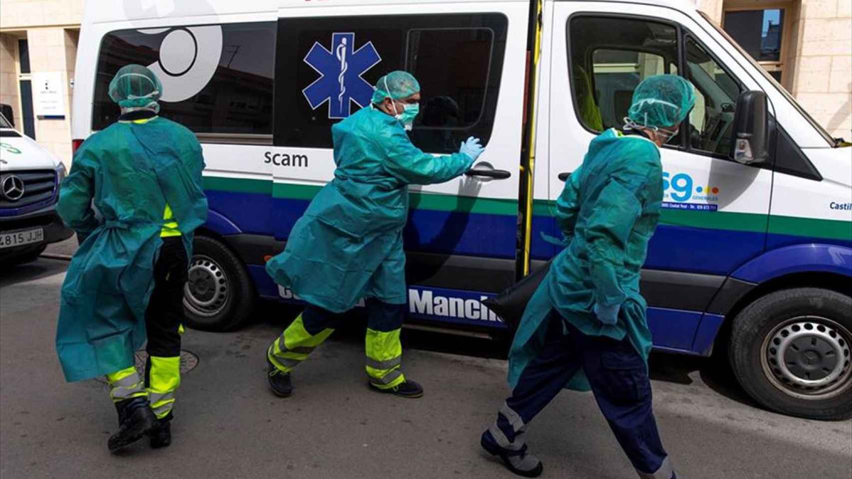 Tres sanitarios ante una ambulancia