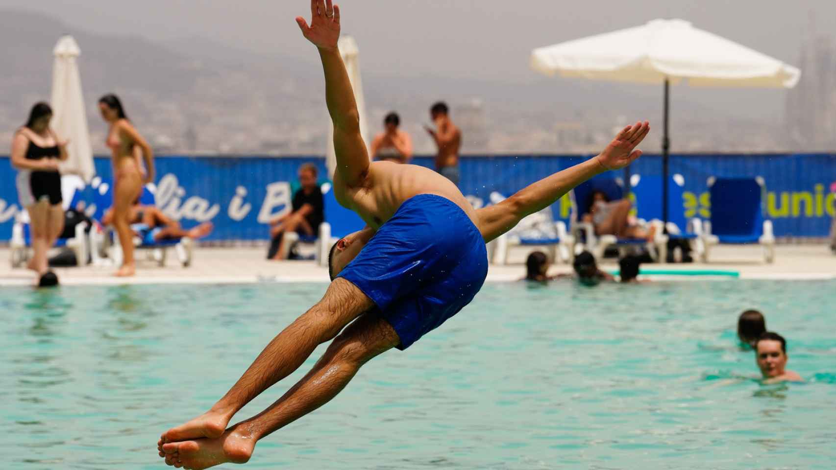 Varias personas se refrescan en las Piscinas Municipales de Montjuic este martes, cuando Cataluña sufre hoy el pico de la canícula