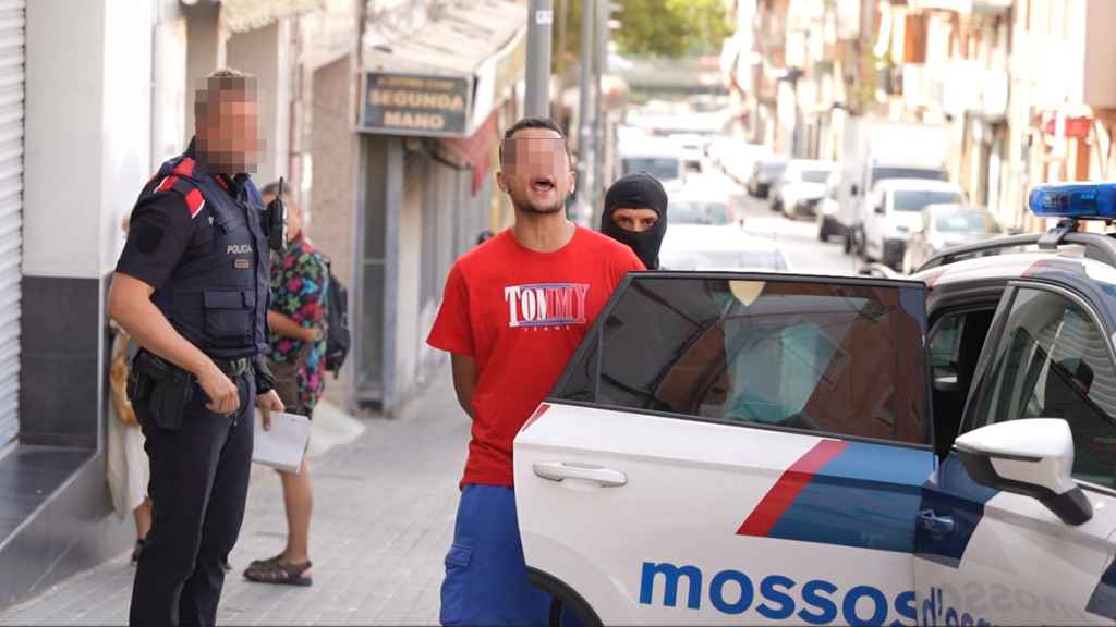 Salida del detenido de uno de los registros efectuados en Badalona