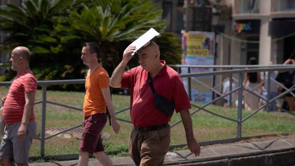 Una persona trata de protegerse del sol en Las Ramblas, a 18 de julio de 2023, en Barcelona,