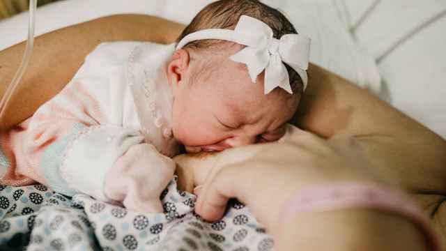 Una mujer da el pecho a un bebé recién nacido en el hospital