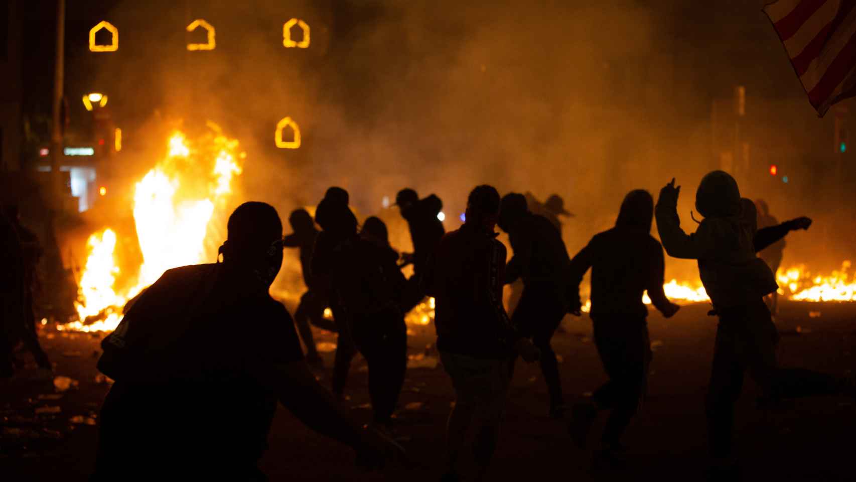 Manifestantes frente al fuego durante los disturbios en la plaza de Urquinaona, en Barcelona a 18 de octubre de 2019