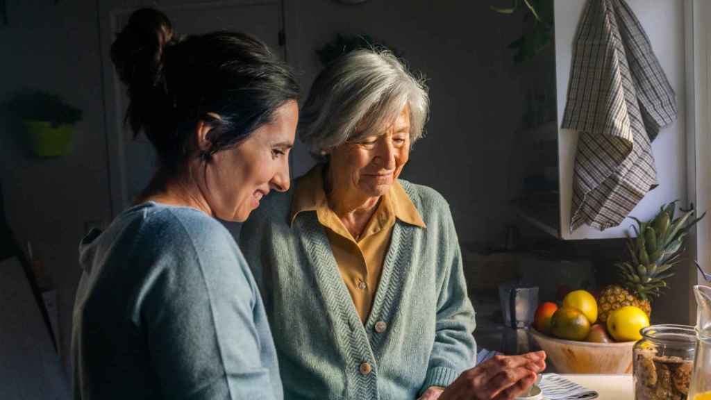 Una persona mayor con su cuidadora