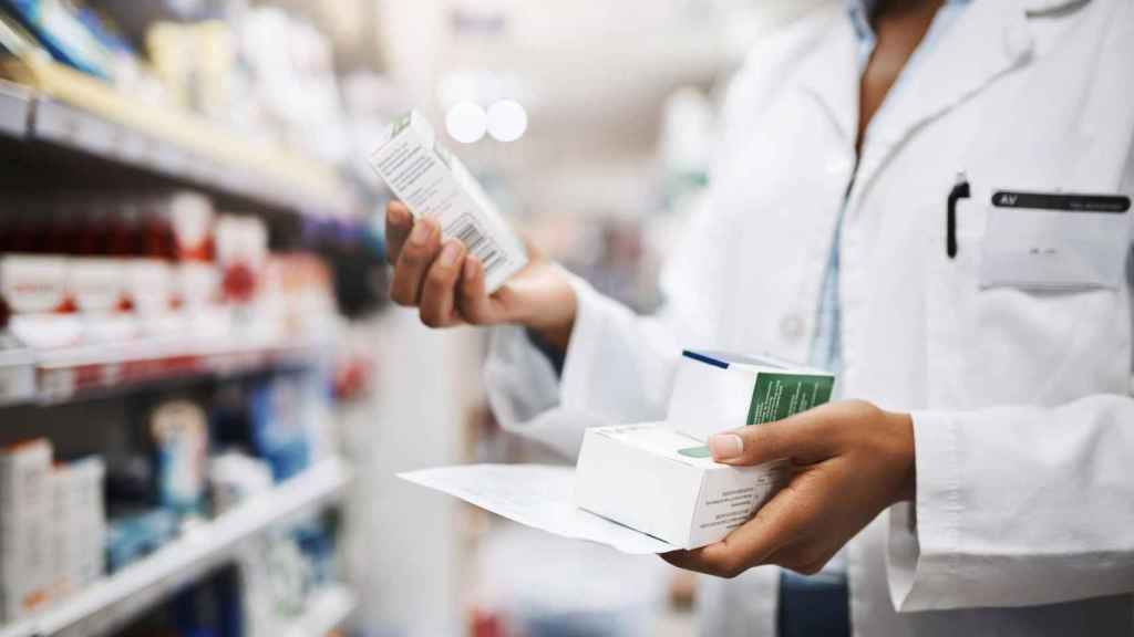 Una boticaria consulta medicamentos en una farmacia