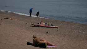 Varias personas toman el sol en la playa de la Barceloneta