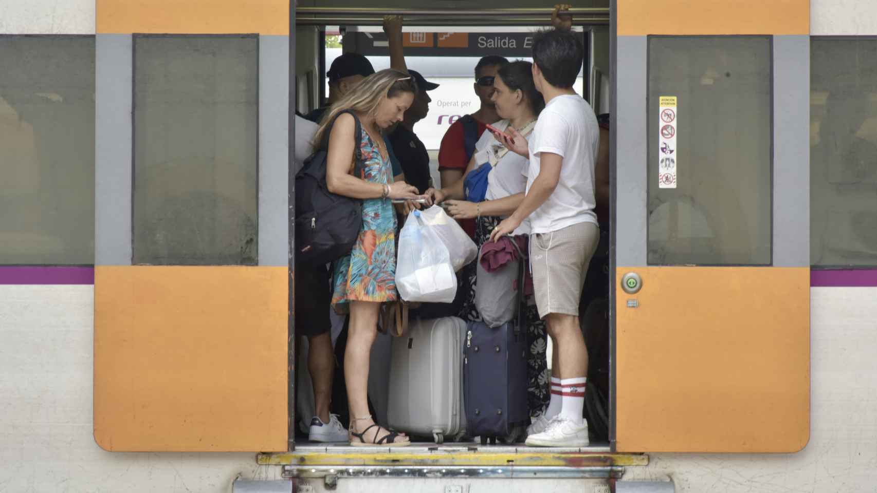 Varias personas en el interior de un tren en Vilanova i la Geltrú