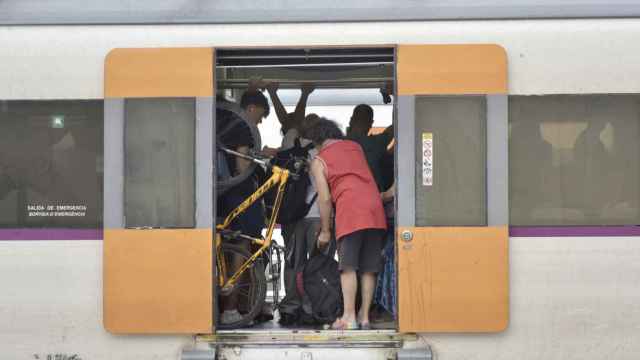 Varias personas en el interior de un tren en Vilanova i la Geltrú, una de las estaciones afectadas, a 16 de agosto de 2023, en Vilanova i la Geltrú, Barcelona