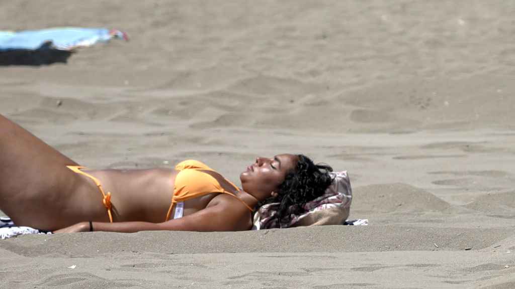 Una mujer toma el sol en la playa