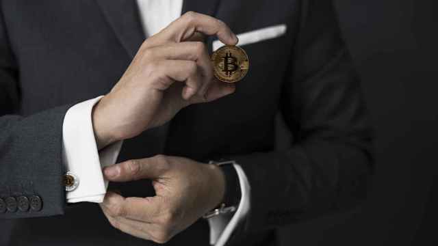 Hombre de negocios sostiene un Bitcoin