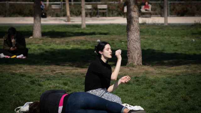 Una joven bebe agua mientras toma el sol en Barcelona