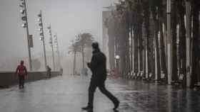 Un hombre camina por el paseo marítimo de Barcelona en una imagen de archivo