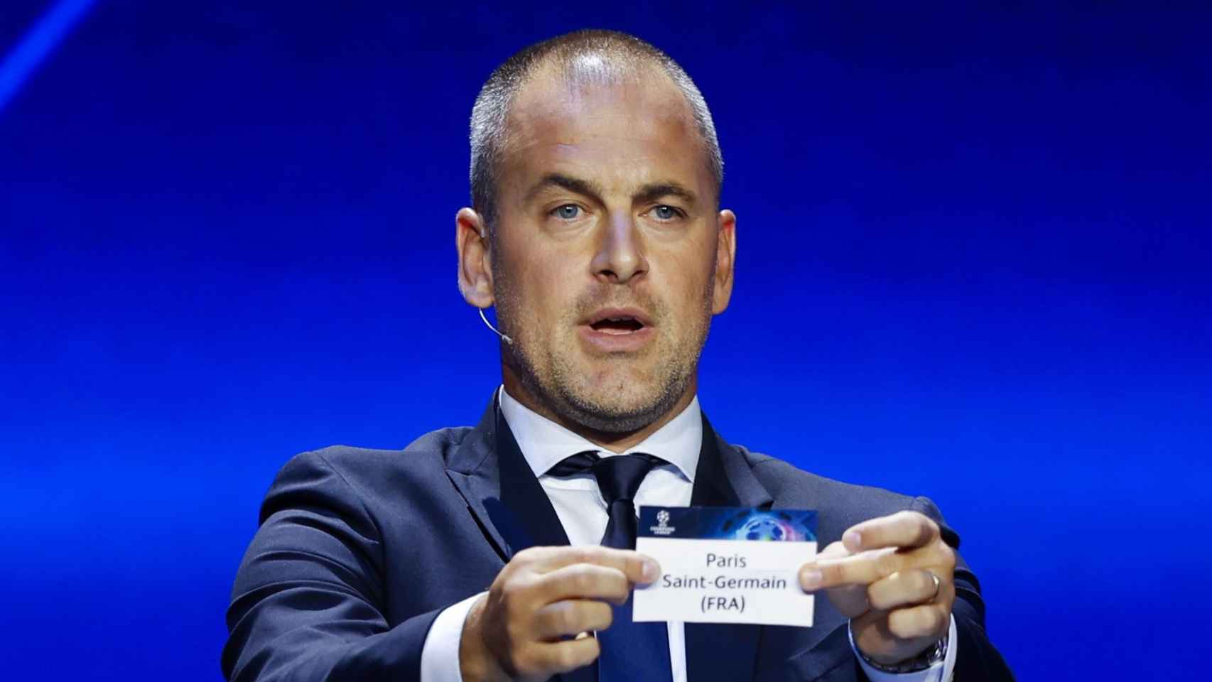 Joe Cole muestra la papeleta del PSG en el sorteo de la Champions League 2023-24