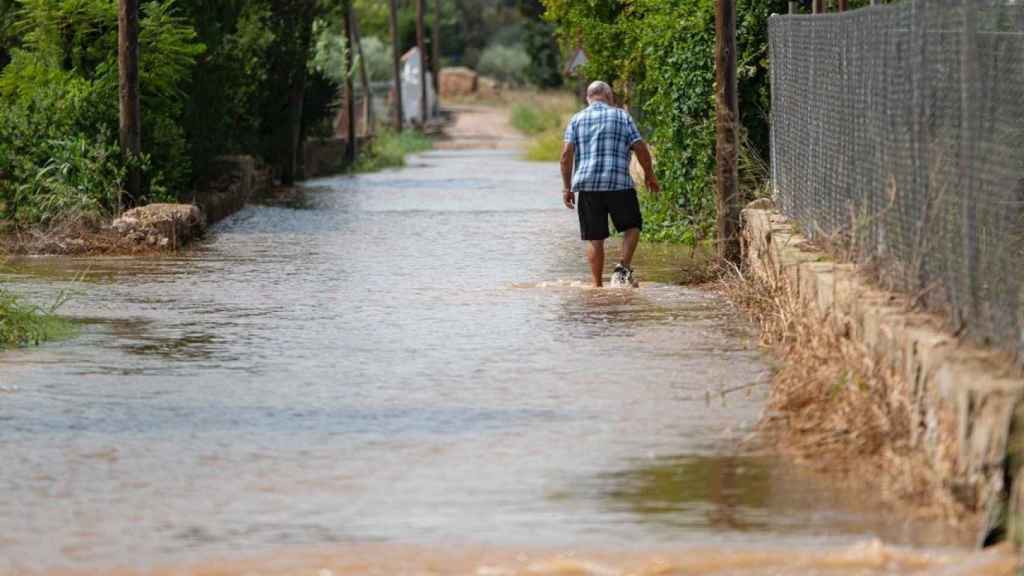 Imagen de un vecino en un camino anegado por la lluvia