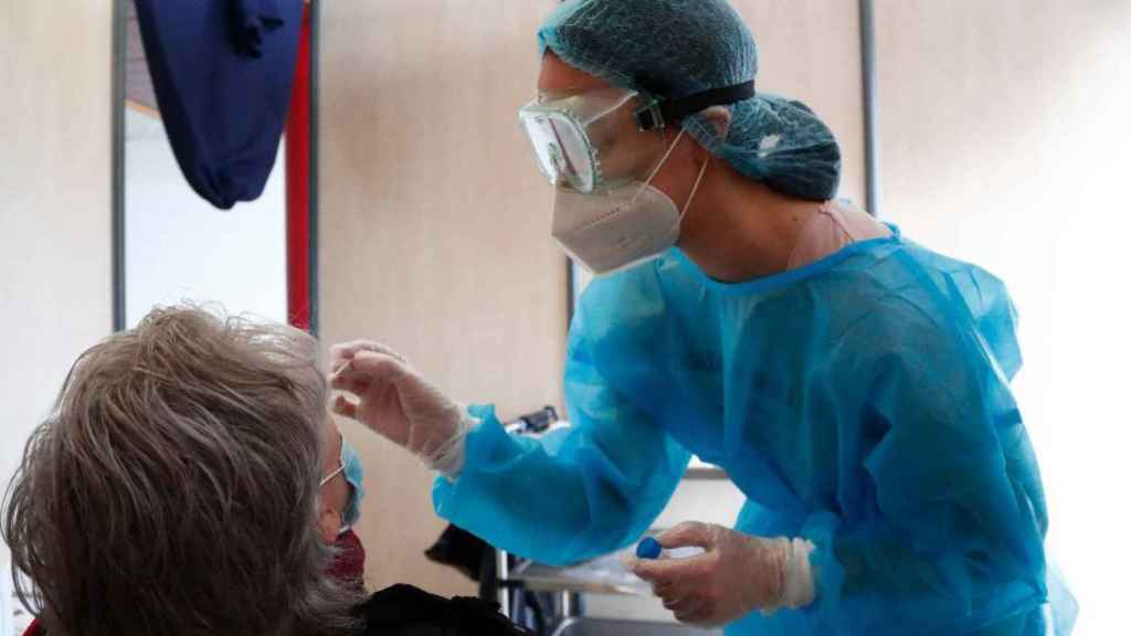 Imagen de un sanitario atendiendo a una paciente en Francia