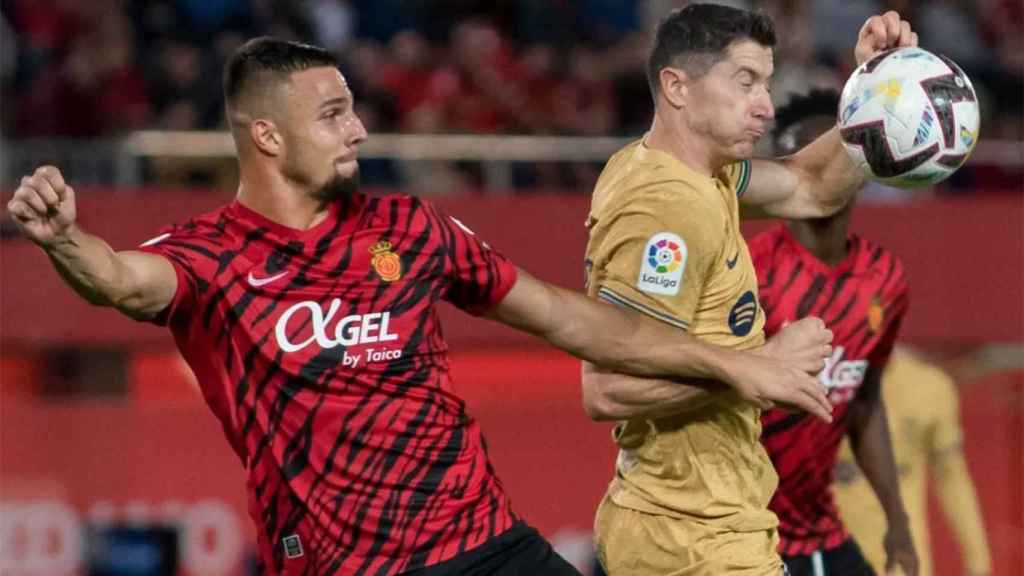 Robert Lewandowski, luchando por un balón con un jugador del Mallorca