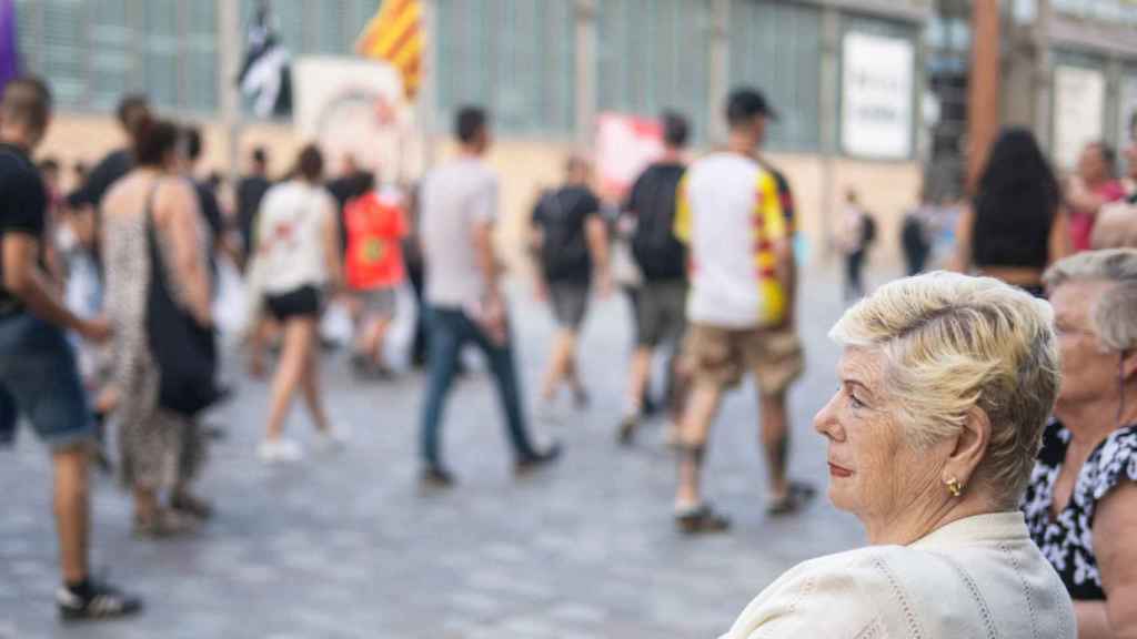 Vecinas de Barcelona miran una marcha independentista en la Diada de este año