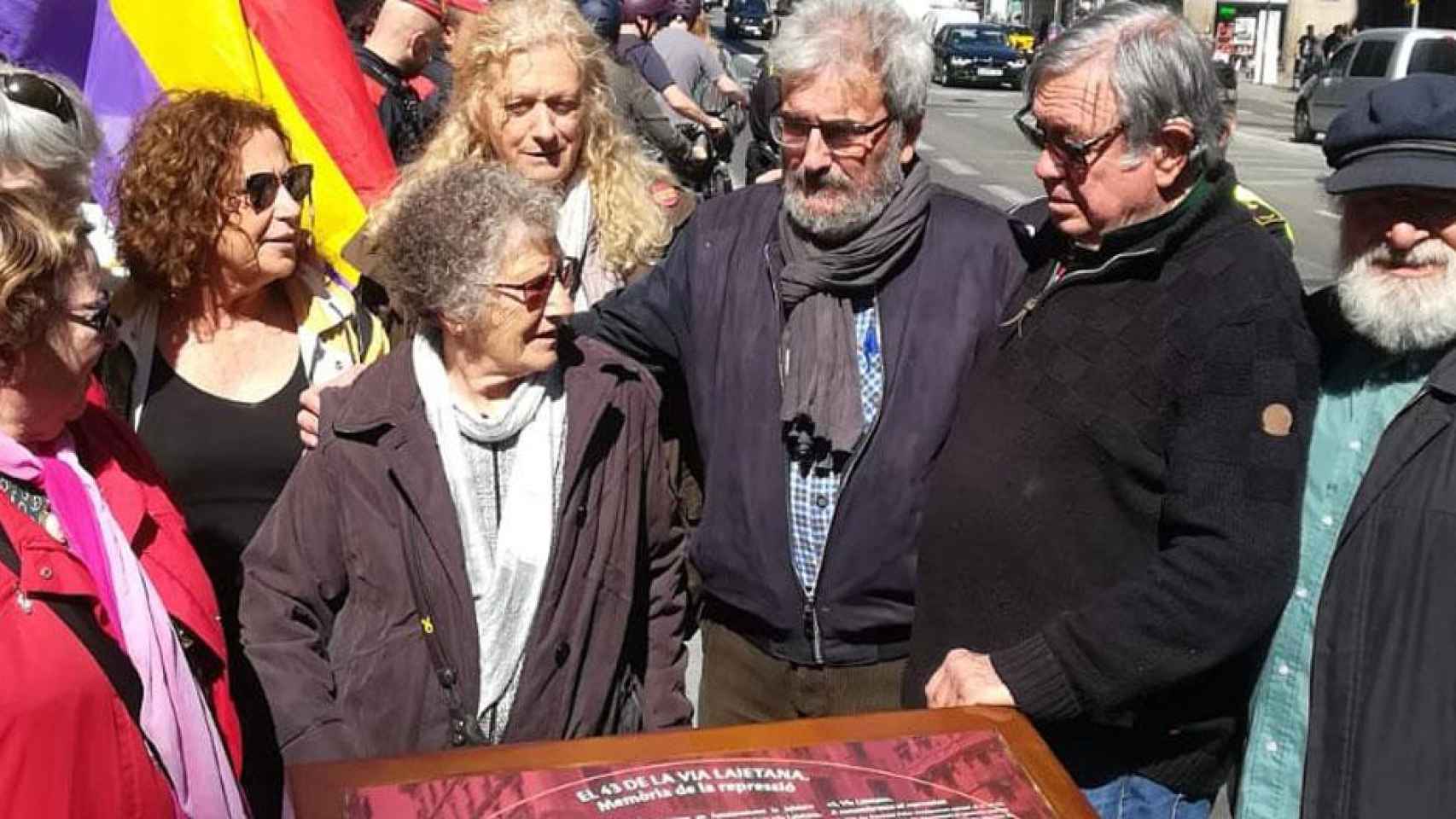 Carles Vallejo (en el centro, con barba) junto a la placa memorial de Via Laietana 43