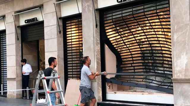 Dos operarios limpian la 'boutique' de Chanel alunizada por los cacos