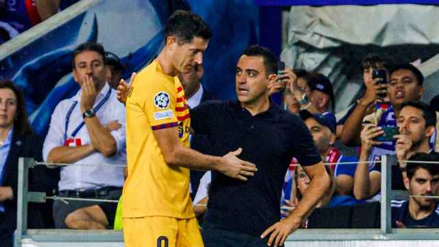 Xavi consuela a Lewandowski después de sufrir una lesión en el Oporto-Barça
