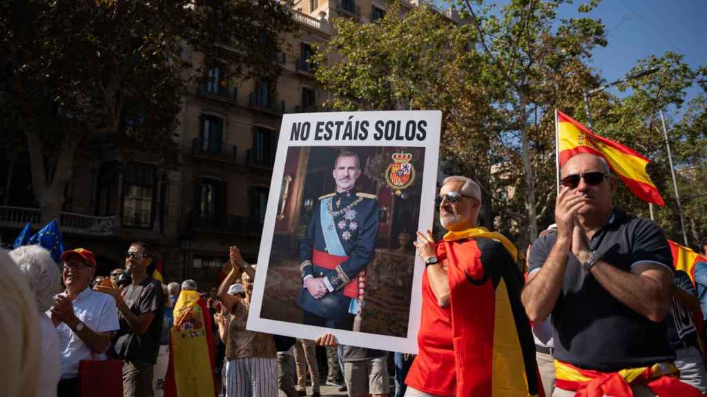 Un manifestante junto a una foto del rey Felipe VI