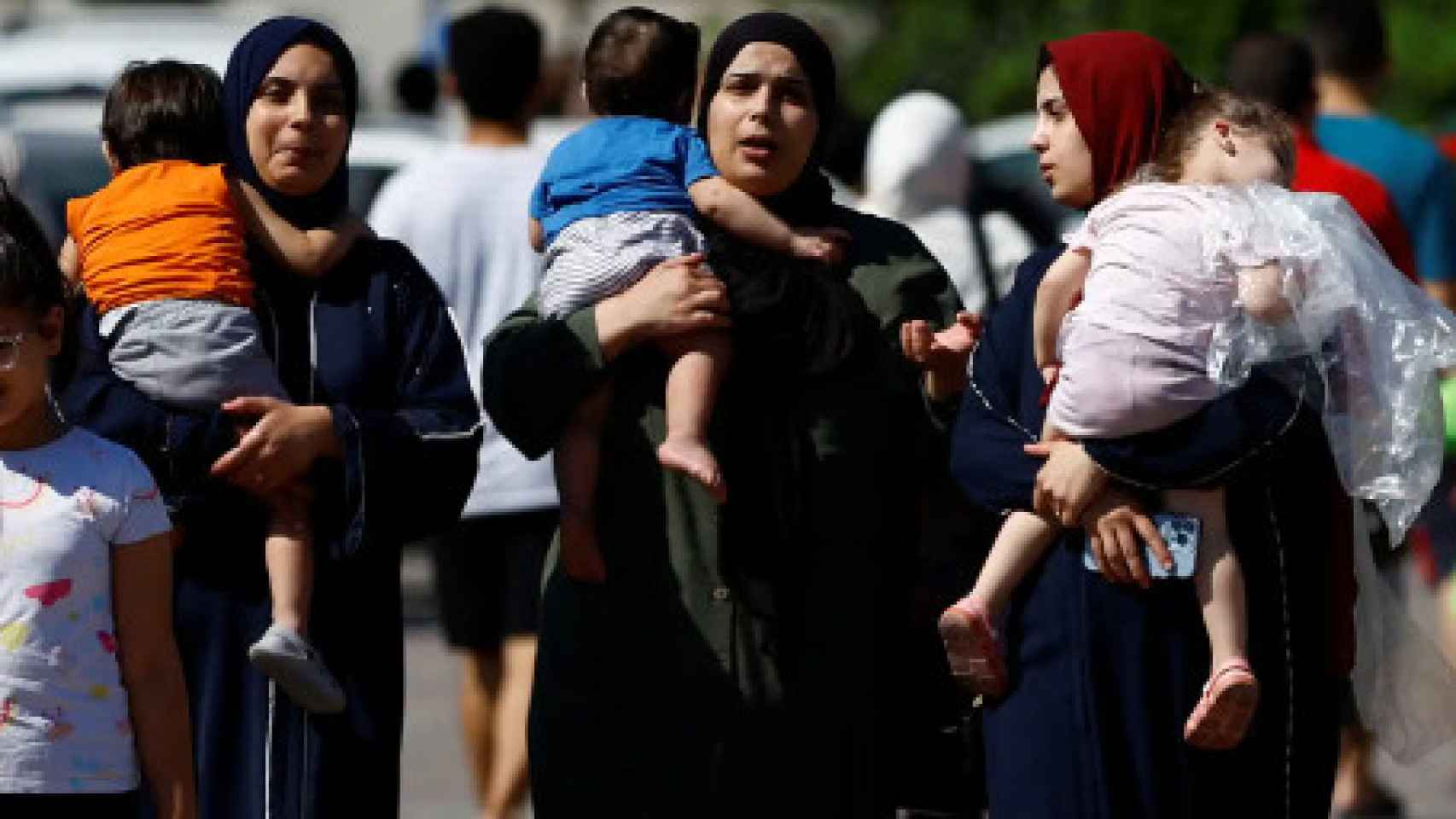 Madres trasladad a sus hijos en la Franja de Gaza