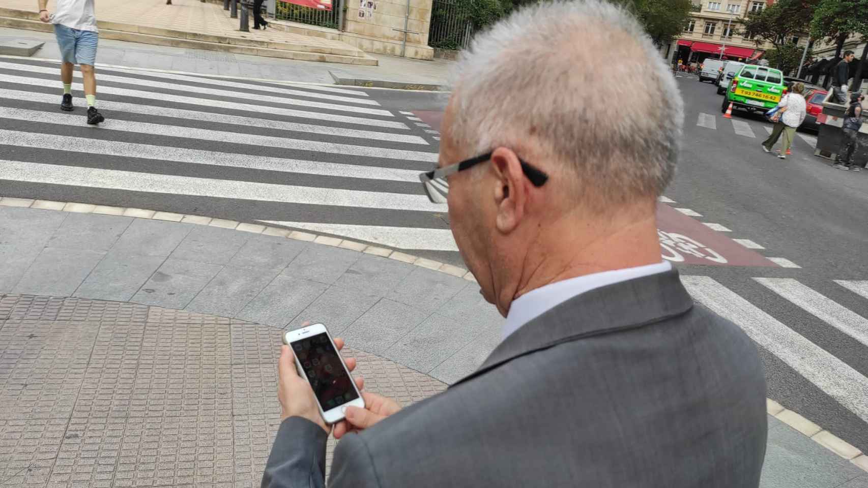 Santiago, uno de los porteros de la zona alta de Barcelona, consulta el grupo de Whatsapp con el que se comunica con sus compañeros