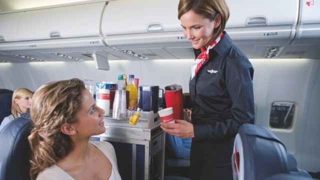 Una azafata sirve bebidas en un vuelo