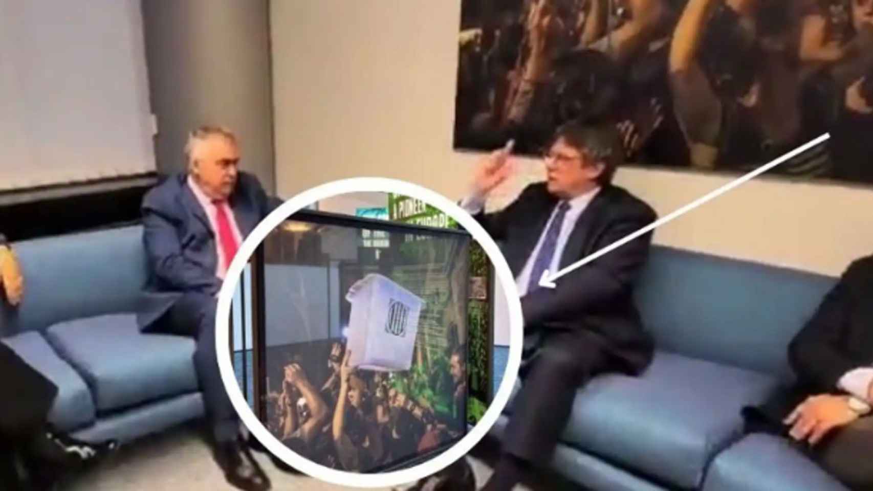 Santos Cerdán (PSOE) y Puigdemont (Junts), reunidos ante una foto de una urna del referéndum ilegal y unilateral de secesión del 1-O, retirada por el Parlamento europeo