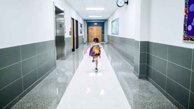 Niño corriendo por el pasillo de un colegio