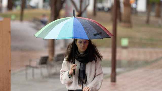Una joven camina con un paraguas en Barcelona