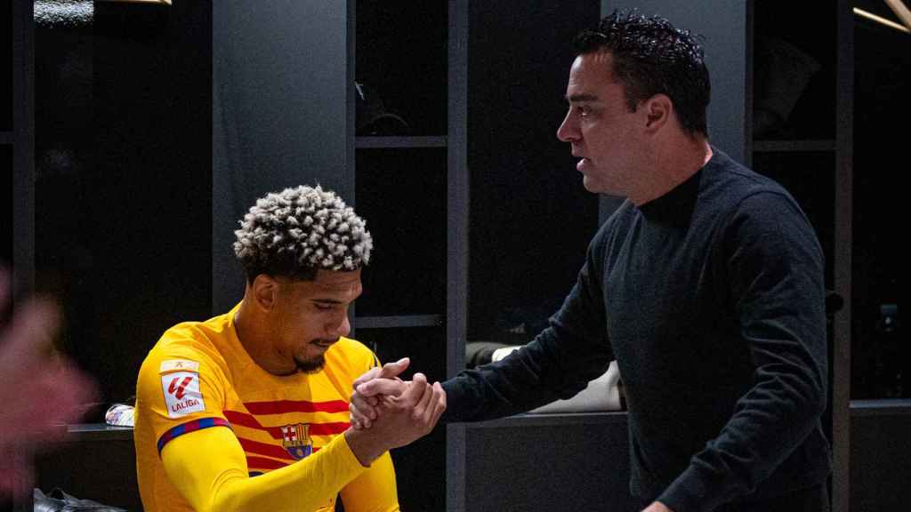 Xavi aprieta la mano de Araujo en el vestuario visitante en Anoeta