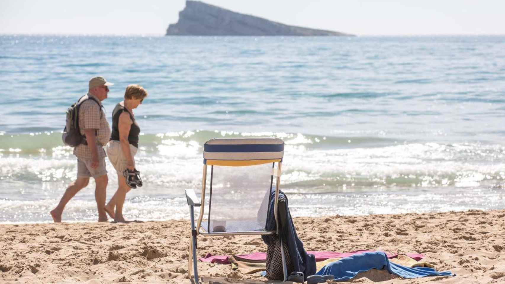 Dos personas mayores pasean por la playa