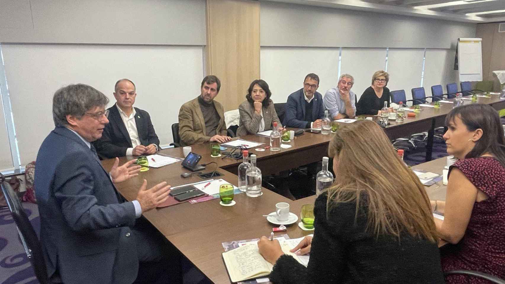 El expresidente de la Generalitat Carles Puigdemont (i) junto a Jordi Turull (i-fondo) y Laura Borrás (d), entre otros miembros de la cúpula de JxCat, durante una reunión en Bélgica para decidir si valida un acuerdo para investir a Pedro Sánchez