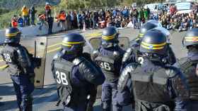 Agentes de policía frente a la multitud que ha cortado la carretera de la AP-7 en La Jonquera (Girona), una acción convocada por Tsunami Democràtic, en La Jonquera, en 2019